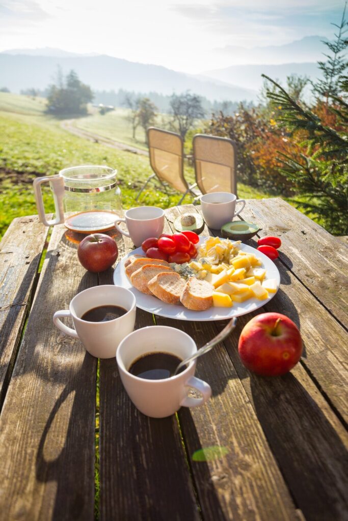 Picnicin farm morning mountains cheeses baguette tomatoes avocado coffee wooden table 522472 4718